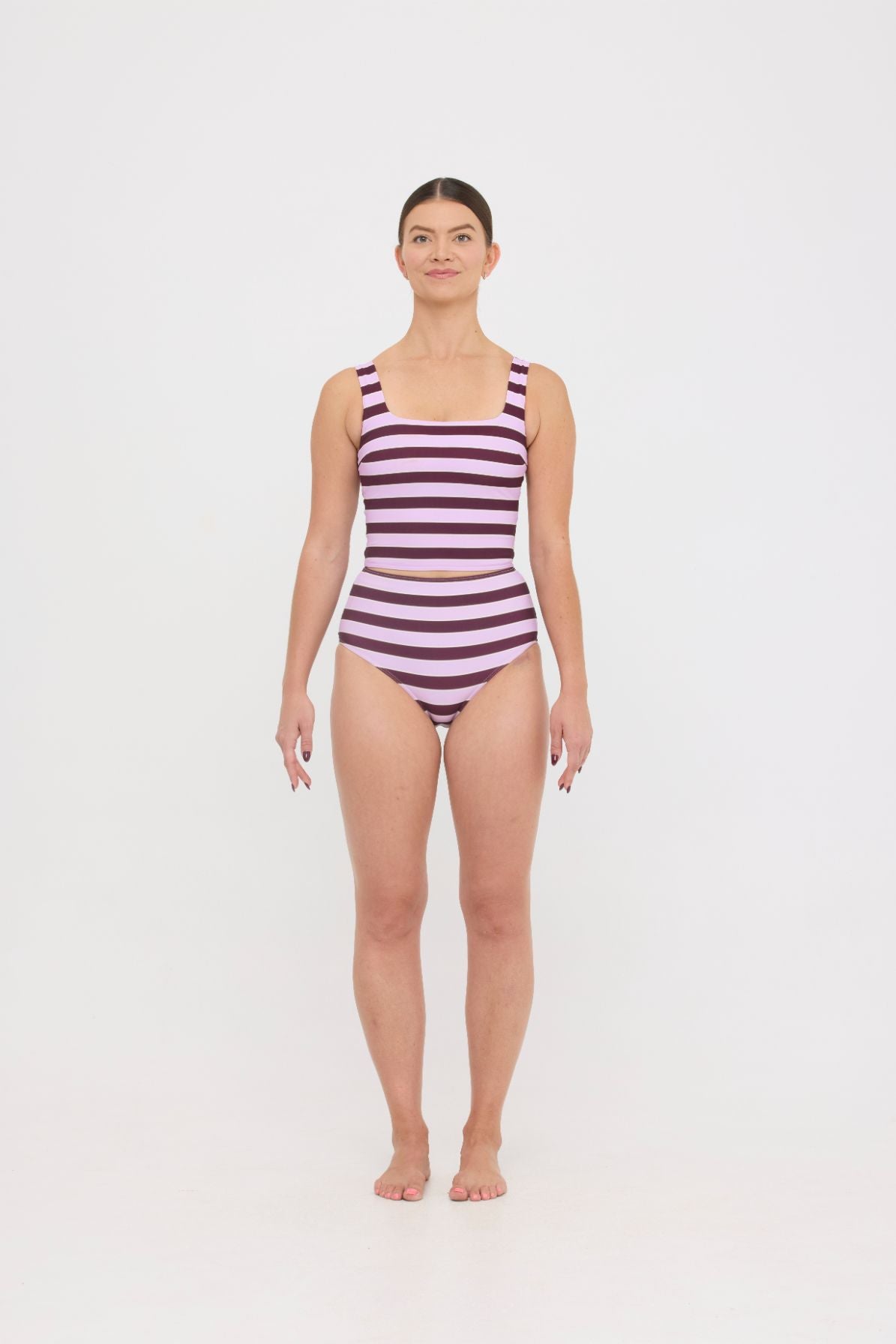 Model in Violet and Plum mixed-stripe HUZZAH Ted tank and high-waisted full-coverage bikini bottoms against white background.