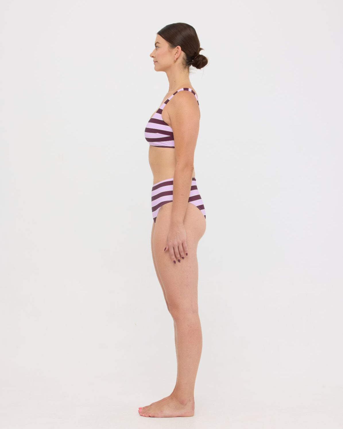 Model in Violet and Plum mixed-stripe HUZZAH Chilli crop bikini top paired with mid-waisted full-coverage bottoms