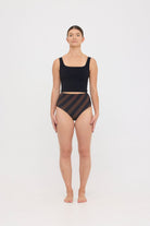 Model in black sculpting HUZZAH Ted tank and espresso and black rising stripe high-waisted full-coverage bikini bottoms against white background.