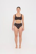 Woman wearing espresso and black rising-stripe HUZZAH Chilli crop top with high-waisted full-coverage bikini bottoms on white background.