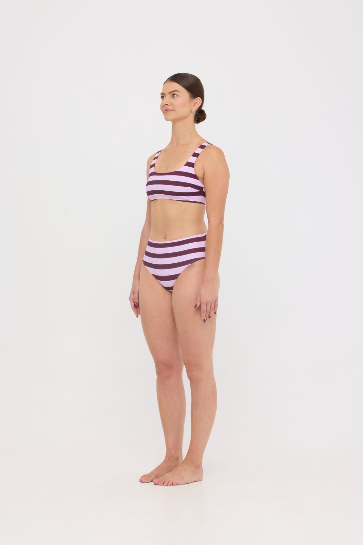 Model in Violet and Plum mixed-stripe HUZZAH Chilli crop bikini top paired with mid-waisted full-coverage bottoms
