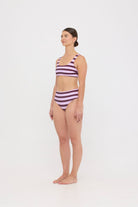 Model in Violet and Plum mixed-stripe HUZZAH Chilli crop bikini top paired with mid-waisted full-coverage bottoms
