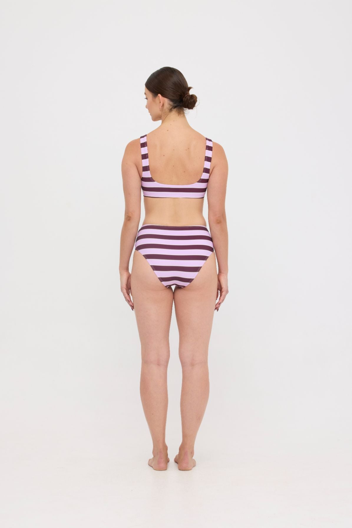 Model in Violet and Plum mixed-stripe HUZZAH Chilli crop bikini top paired with mid-waisted full-coverage bottoms
