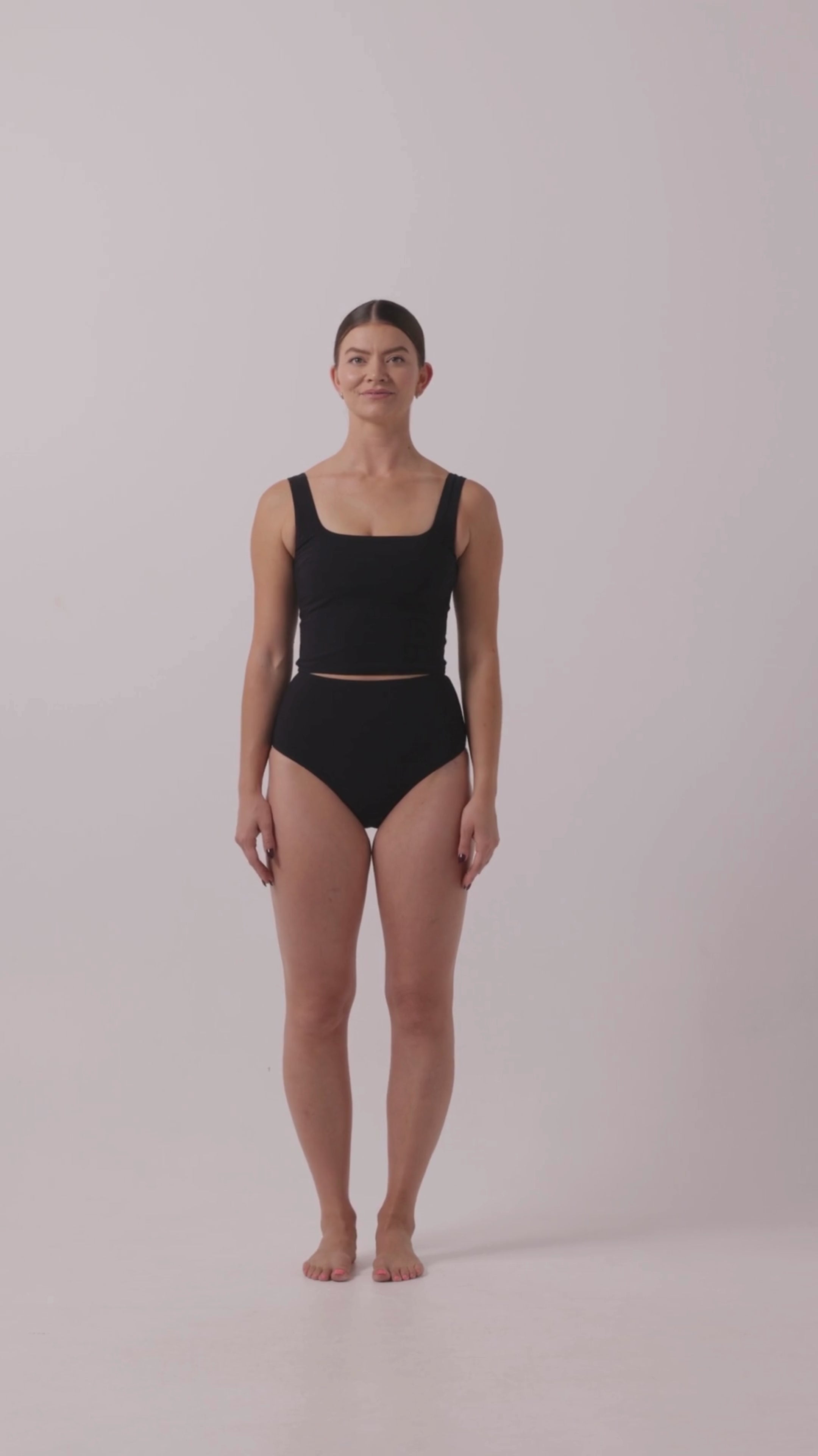 Model in Black HUZZAH Ted tank and high-waisted full-coverage bikini bottoms against white background