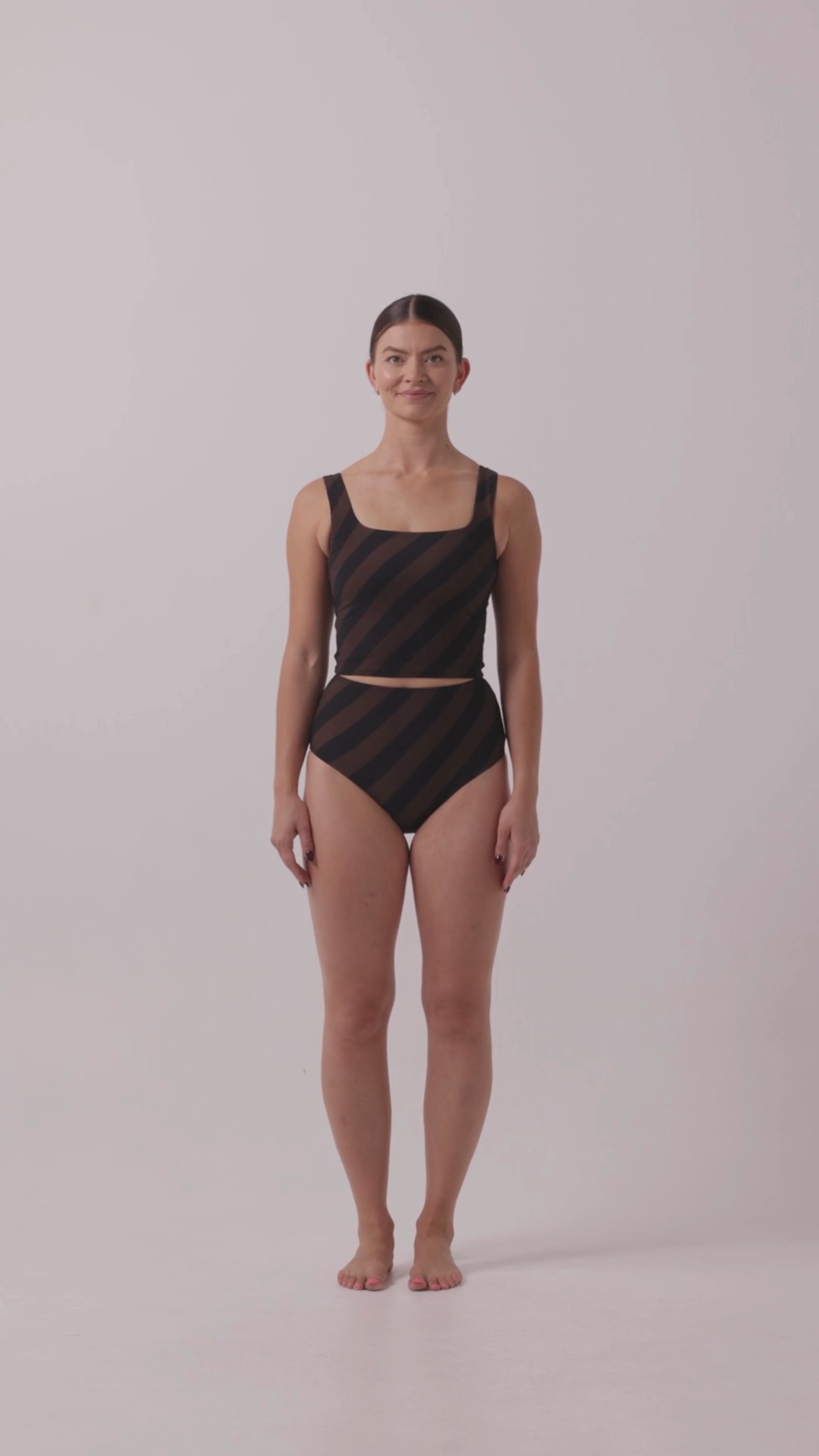 Model in Black HUZZAH Ted tank and high-waisted full-coverage bikini bottoms against white background